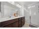 Bathroom featuring double sinks, dark wood cabinets, and glass shower doors at 6626 Evander St, North Las Vegas, NV 89086