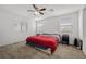 Bright bedroom featuring a ceiling fan, two windows, and neutral carpet at 6626 Evander St, North Las Vegas, NV 89086