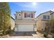 Charming two-story home featuring a white garage door, brick driveway, and well-maintained landscaping at 6626 Evander St, North Las Vegas, NV 89086
