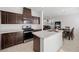 Modern kitchen featuring dark cabinetry, stainless steel appliances, quartz countertops, and a center island at 6626 Evander St, North Las Vegas, NV 89086