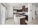 Updated kitchen features dark wood cabinets, stainless steel appliances, and a center island with sink at 6626 Evander St, North Las Vegas, NV 89086