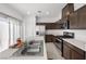 Well-equipped kitchen boasts stainless steel appliances, quartz countertops, and dark wood cabinets at 6626 Evander St, North Las Vegas, NV 89086