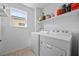 Well-lit laundry area with a window and storage shelf above the washer and dryer at 6626 Evander St, North Las Vegas, NV 89086
