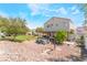 Large backyard with fire pit, covered patio, green grass, and desert landscaping at 6715 Maple Mesa St, North Las Vegas, NV 89084