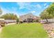 Expansive backyard with artificial grass, covered patio, and desert landscaping at 6715 Maple Mesa St, North Las Vegas, NV 89084