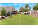 Large backyard with artificial grass, desert landscaping, and mature trees at 6715 Maple Mesa St, North Las Vegas, NV 89084