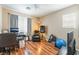 A spacious room with wood floors, a ceiling fan, and large windows that provide lots of natural light at 6715 Maple Mesa St, North Las Vegas, NV 89084