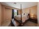 Bedroom featuring a four-poster bed, plush bedding, natural light, and a cozy ambiance at 675 Harbor Mist Ave, Henderson, NV 89015