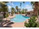 Community pool with lush landscaping, lounge seating, and a covered picnic area on a sunny day at 675 Harbor Mist Ave, Henderson, NV 89015