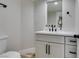 A bathroom featuring a sink, mirror, hardware, and toilet at 71 Sea Holly Way, Henderson, NV 89074
