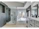 Elegant bathroom featuring a soaking tub, glass enclosed shower, and modern vanity at 71 Sea Holly Way, Henderson, NV 89074