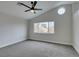 A spacious bedroom features plush gray carpeting, a ceiling fan, and a large window at 71 Sea Holly Way, Henderson, NV 89074