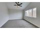 A spacious bedroom features plush gray carpeting, a ceiling fan, and a large window at 71 Sea Holly Way, Henderson, NV 89074