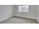 Bedroom with carpet, white baseboards, and a view of the street from the window at 71 Sea Holly Way, Henderson, NV 89074