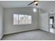 A spacious bedroom with gray carpet features a round window and views to the bathroom at 71 Sea Holly Way, Henderson, NV 89074