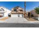 Two-story home featuring a three-car garage, desert landscaping, and a tile roof at 71 Sea Holly Way, Henderson, NV 89074