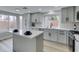Bright kitchen featuring gray cabinets, island, stainless steel appliances, and plenty of natural light at 71 Sea Holly Way, Henderson, NV 89074