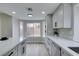 Bright kitchen with a quartz countertop, stainless steel appliances, and gray cabinetry at 71 Sea Holly Way, Henderson, NV 89074