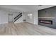 Spacious living room with modern fireplace, stylish lighting, and staircase leading to the upper level at 71 Sea Holly Way, Henderson, NV 89074