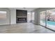 Bright living room features a modern fireplace and sliding glass doors to the outdoor swimming pool at 71 Sea Holly Way, Henderson, NV 89074