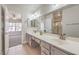 Bright bathroom features double sinks, framed mirrors, and decorative floral accents; adjacent to bedroom at 7300 Breezy Night Ct, Las Vegas, NV 89129