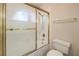 This bathroom showcases a bathtub with framed glass doors and a nearby toilet at 7300 Breezy Night Ct, Las Vegas, NV 89129