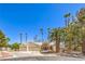 Charming single-story home with a three-car garage and mature palm tree landscaping set against a clear blue sky at 7300 Breezy Night Ct, Las Vegas, NV 89129