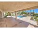Covered patio featuring a pool with beautiful landscaping and palm trees, perfect for relaxing and entertaining outdoors at 7300 Breezy Night Ct, Las Vegas, NV 89129