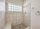 Walk-in shower with tiled walls, bench seating, glass block window and a sleek shower head fixture at 7300 Breezy Night Ct, Las Vegas, NV 89129