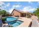 Back exterior view of the home featuring a sparkling pool, spa, and an inviting covered patio at 7559 Chambery Cove Ct, Las Vegas, NV 89123