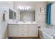 Double vanity bathroom, featuring soaking tub and towel rack, with ample lighting and cabinet space at 7559 Chambery Cove Ct, Las Vegas, NV 89123