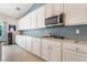 Modern kitchen boasts granite countertops, white cabinetry, stainless steel appliances, and ample storage at 7559 Chambery Cove Ct, Las Vegas, NV 89123