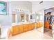 Large primary bathroom features dual sinks, bright lighting and a large walk-in closet at 7909 Sierra Rim Dr, Las Vegas, NV 89131