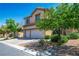 Two-story home with a two-car garage, desert landscaping, and a driveway on a sunny day at 81 Alpine Bay Ave, Las Vegas, NV 89148