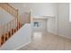 Bright foyer with wooden staircase and neutral tile flooring, leading into an open living area at 81 Alpine Bay Ave, Las Vegas, NV 89148
