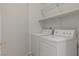 Bright laundry room with a washer, dryer, and built-in storage shelf at 81 Alpine Bay Ave, Las Vegas, NV 89148