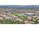 An aerial shot shows a residential community with beautiful terracotta roofs, a green field, and a distant cityscape at 8408 White Eagle Ave # 101, Las Vegas, NV 89145