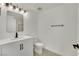 Bathroom featuring a single sink vanity with modern hardware, a toilet, and a walk-in shower with glass door at 8408 White Eagle Ave # 101, Las Vegas, NV 89145