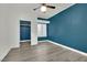 Bedroom featuring a ceiling fan, shutters, luxury vinyl plank flooring, modern color accents, and a walk-in closet at 8408 White Eagle Ave # 101, Las Vegas, NV 89145