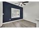 Bright bedroom with a ceiling fan, a large window, and plank flooring at 8408 White Eagle Ave # 101, Las Vegas, NV 89145