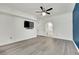 Spacious bedroom with ceiling fan and modern gray flooring, leading to a bathroom at 8408 White Eagle Ave # 101, Las Vegas, NV 89145