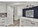 Stylish kitchen featuring white cabinets, gray backsplash, and view of the fireplace at 8408 White Eagle Ave # 101, Las Vegas, NV 89145