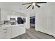 Open concept kitchen with stainless steel appliances, white cabinets and flooring, and an adjacent room at 8408 White Eagle Ave # 101, Las Vegas, NV 89145