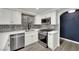 Modern kitchen featuring stainless steel appliances, white cabinets, gray backsplash, and quartz countertops at 8408 White Eagle Ave # 101, Las Vegas, NV 89145