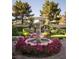 An ornate water fountain surrounded by lush rose bushes enhances the garden's charm at 8620 W La Madre Way, Las Vegas, NV 89149