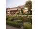A lush landscape features a pergola with creeping plants, and trimmed hedges defining the yard at 8620 W La Madre Way, Las Vegas, NV 89149