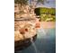 Elegant rock-faced pool with stone water feature creating a tranquil backyard oasis at 8620 W La Madre Way, Las Vegas, NV 89149