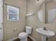 Powder room with pedestal sink, toilet, modern fixtures, and window at 8728 Tom Noon Ave # 103, Las Vegas, NV 89178