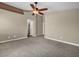 A spacious carpeted bedroom with a ceiling fan, a hallway entrance and neutral colored walls at 8728 Tom Noon Ave # 103, Las Vegas, NV 89178