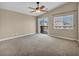 Neutral bedroom featuring a ceiling fan, gray carpet, and a sliding glass door to a balcony at 8728 Tom Noon Ave # 103, Las Vegas, NV 89178